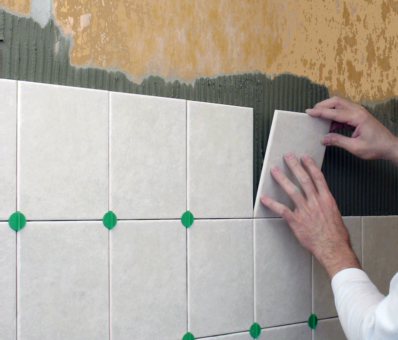 мастер по покраске плитки. укладка плитки на штукатурку в ванной. класть плитку краску ванной. робот укладывает плитку. укладка плитки в ванной на стены.